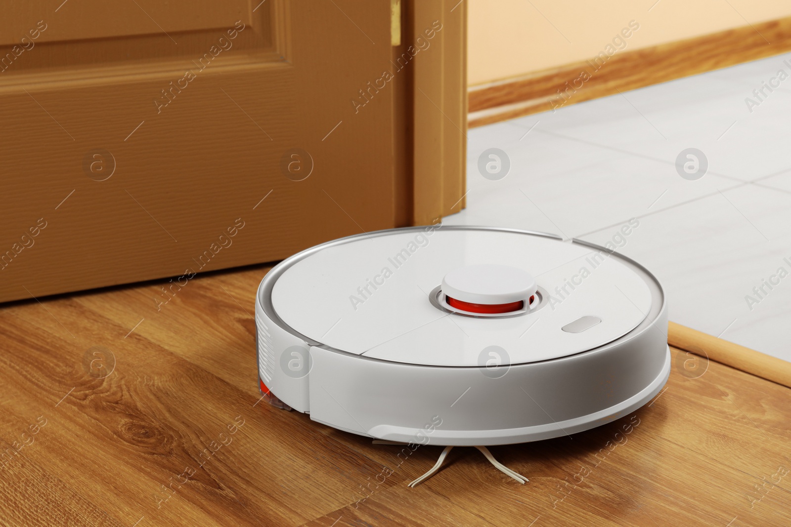 Photo of Modern robotic vacuum cleaner on wooden floor indoors