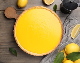 Delicious homemade lemon pie and fresh fruits on wooden table, flat lay