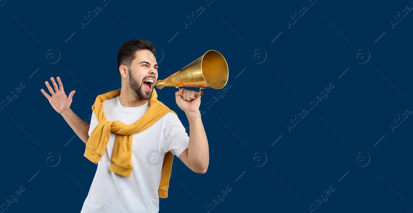 Photo of Young man with megaphone on blue background