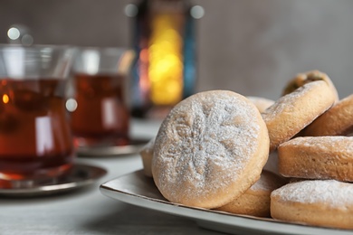 Photo of Traditional Islamic cookies and tea on table, space for text. Eid Mubarak