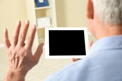 Photo of Man using video chat on tablet at home, closeup. Space for text