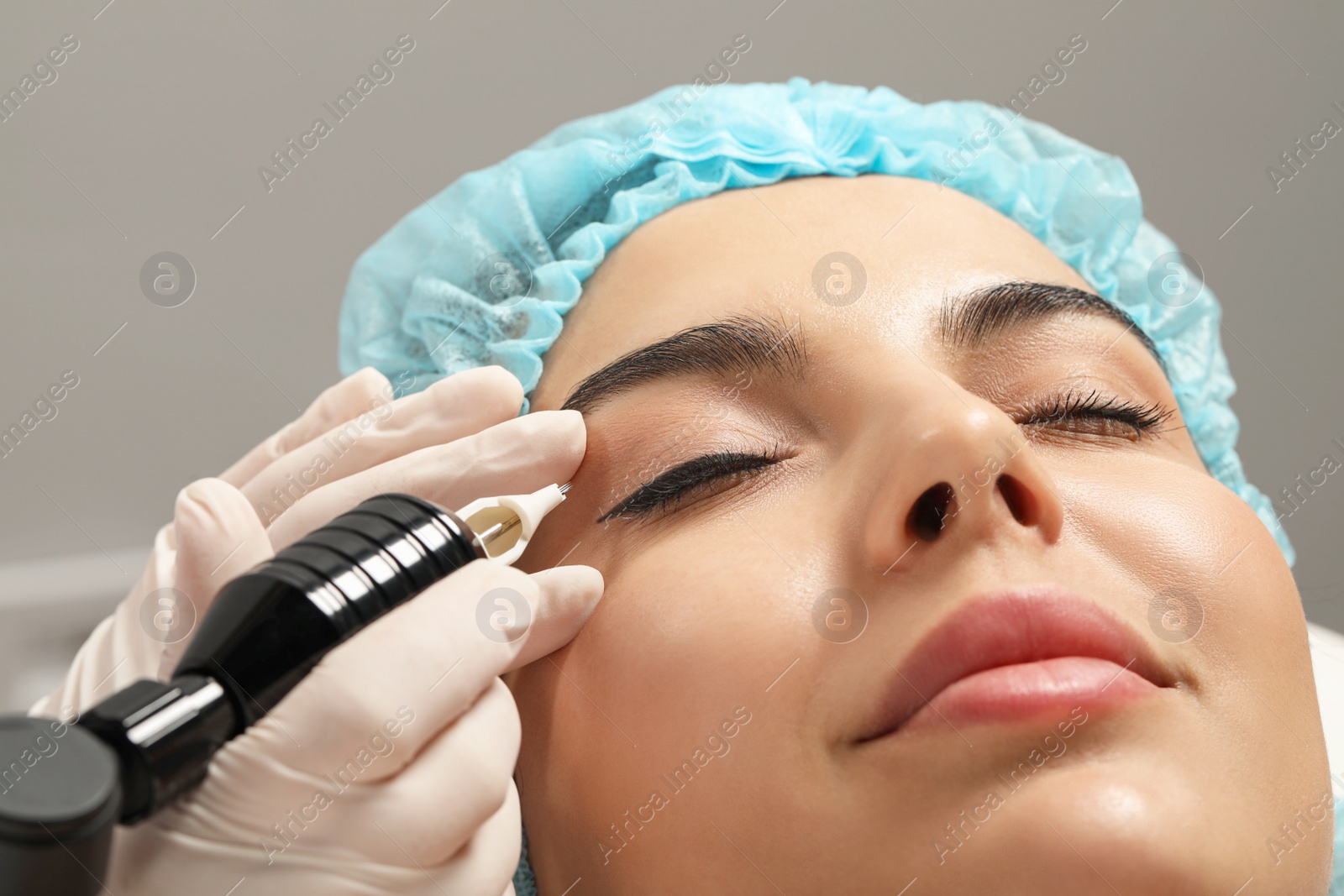 Photo of Young woman undergoing procedure of permanent eyeliner makeup, closeup