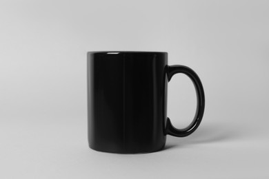 Photo of Black ceramic mug on light grey background