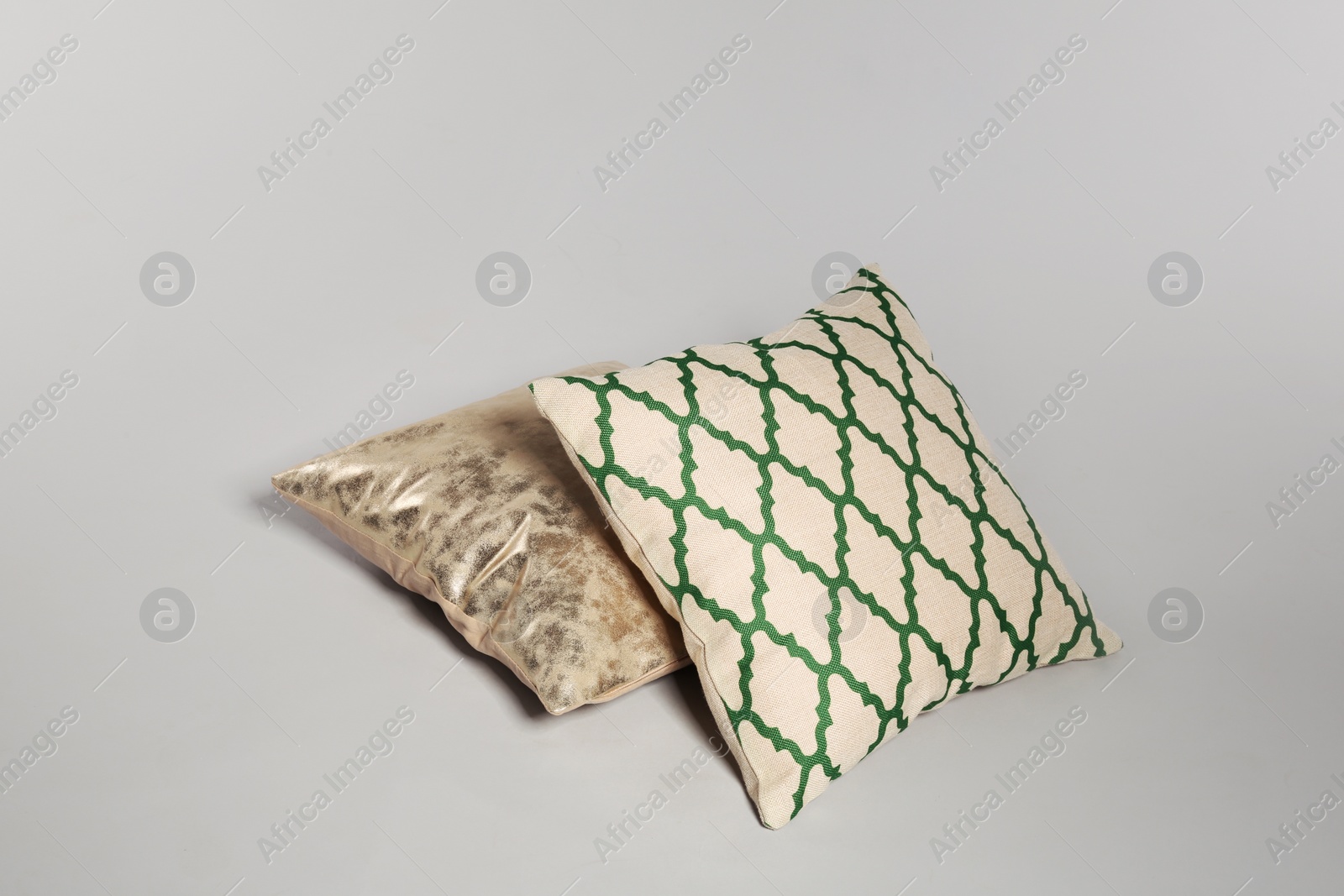 Photo of Two stylish decorative pillows on light background