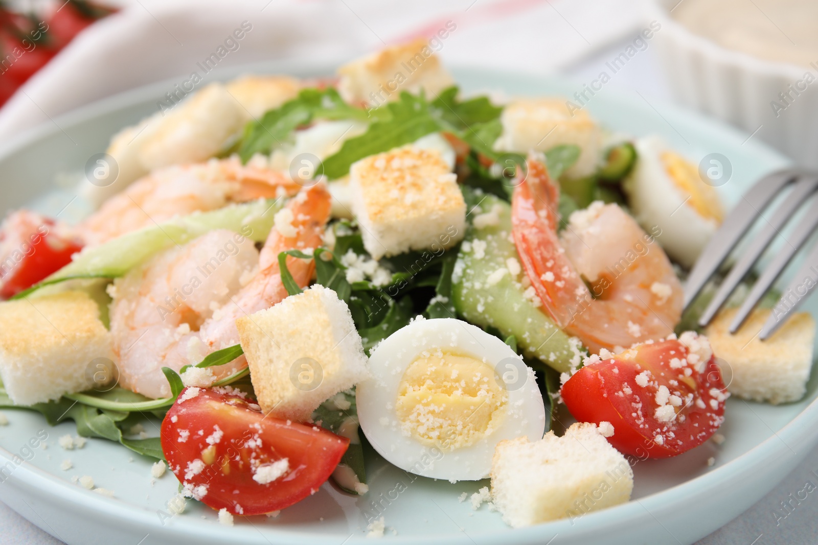 Photo of Delicious Caesar salad with shrimps on plate, closeup