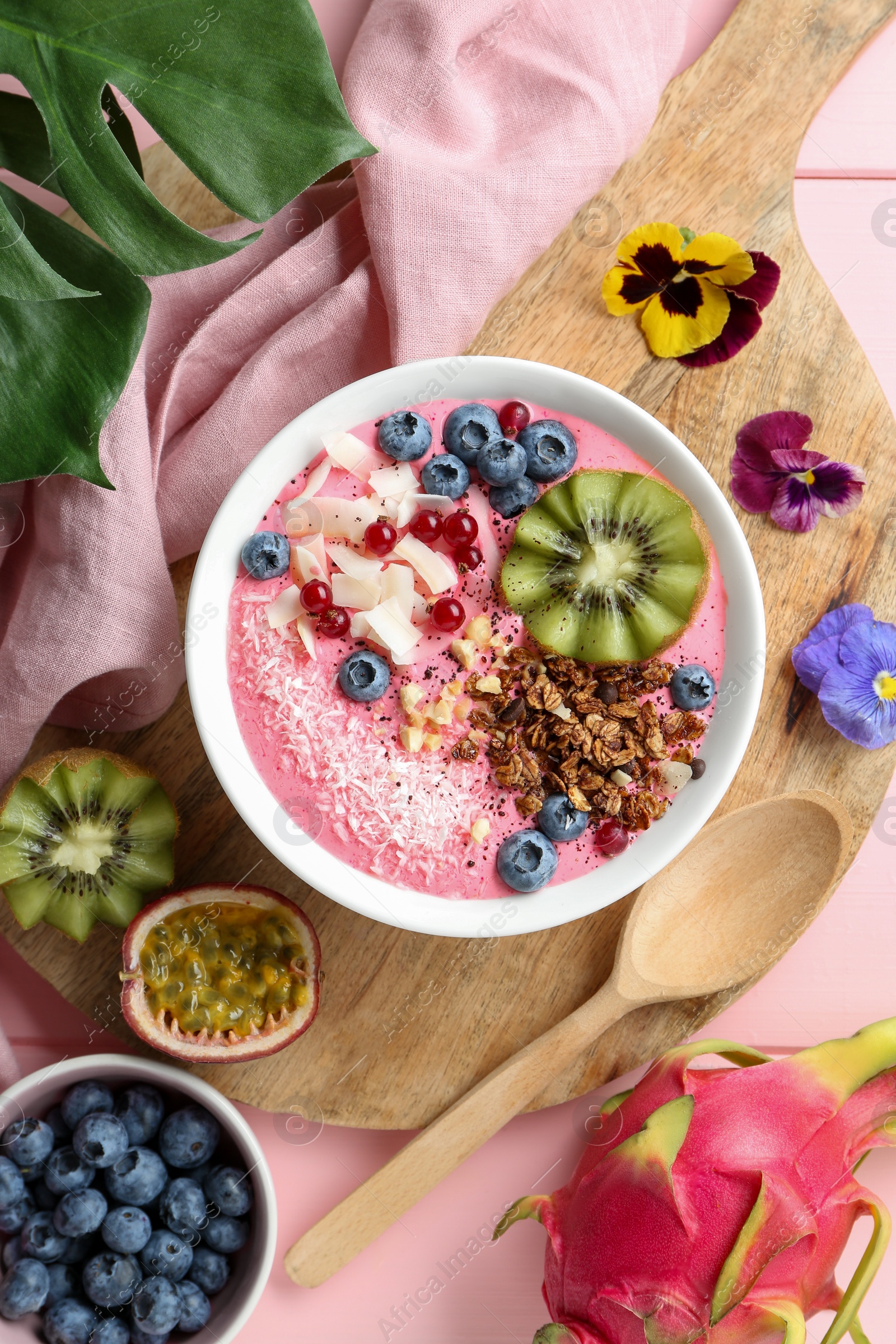 Photo of Flat lay composition with tasty smoothie bowl on pink table