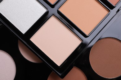 Colorful contouring palettes as background, closeup. Professional cosmetic product