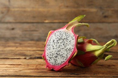 Delicious cut and whole dragon fruits (pitahaya) on wooden table