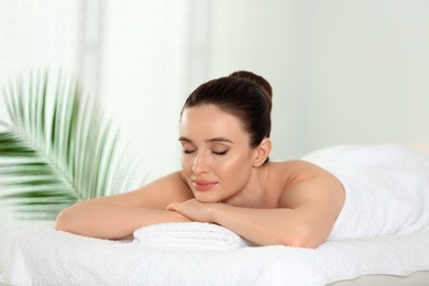 Beautiful young woman relaxing in spa salon