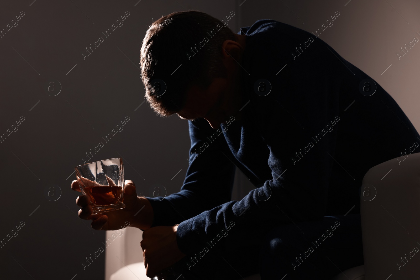 Photo of Addicted man with alcoholic drink on sofa indoors