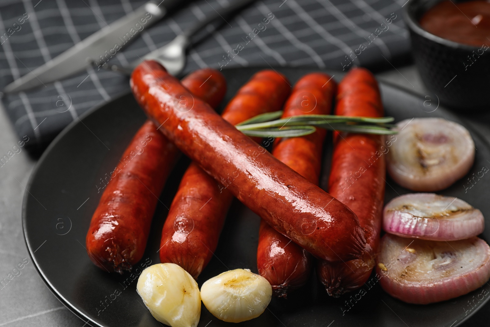 Photo of Delicious grilled sausages and vegetables on plate, closeup. Barbecue food