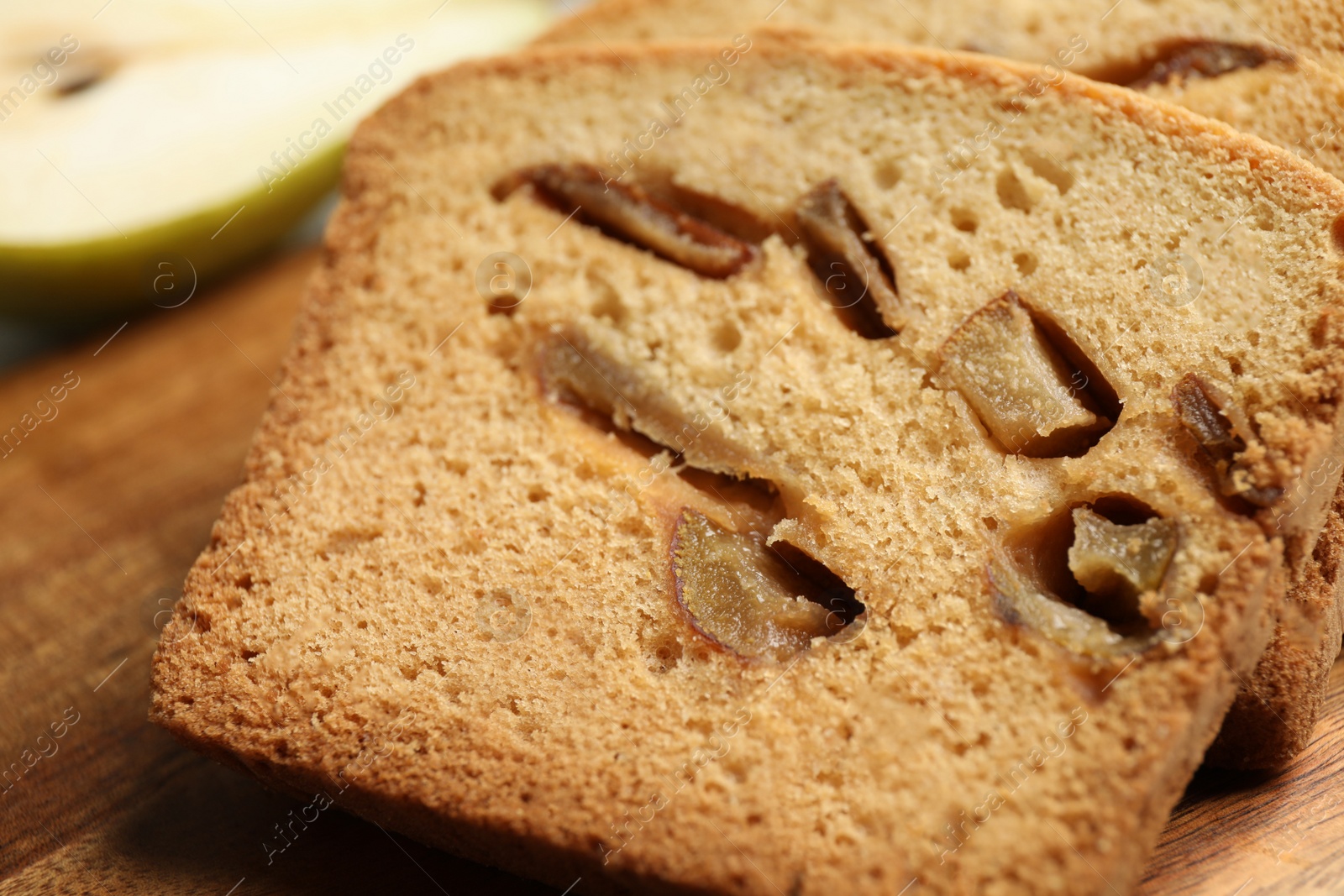 Photo of Slices of tasty pear bread on wooden board, closeup. Homemade cake