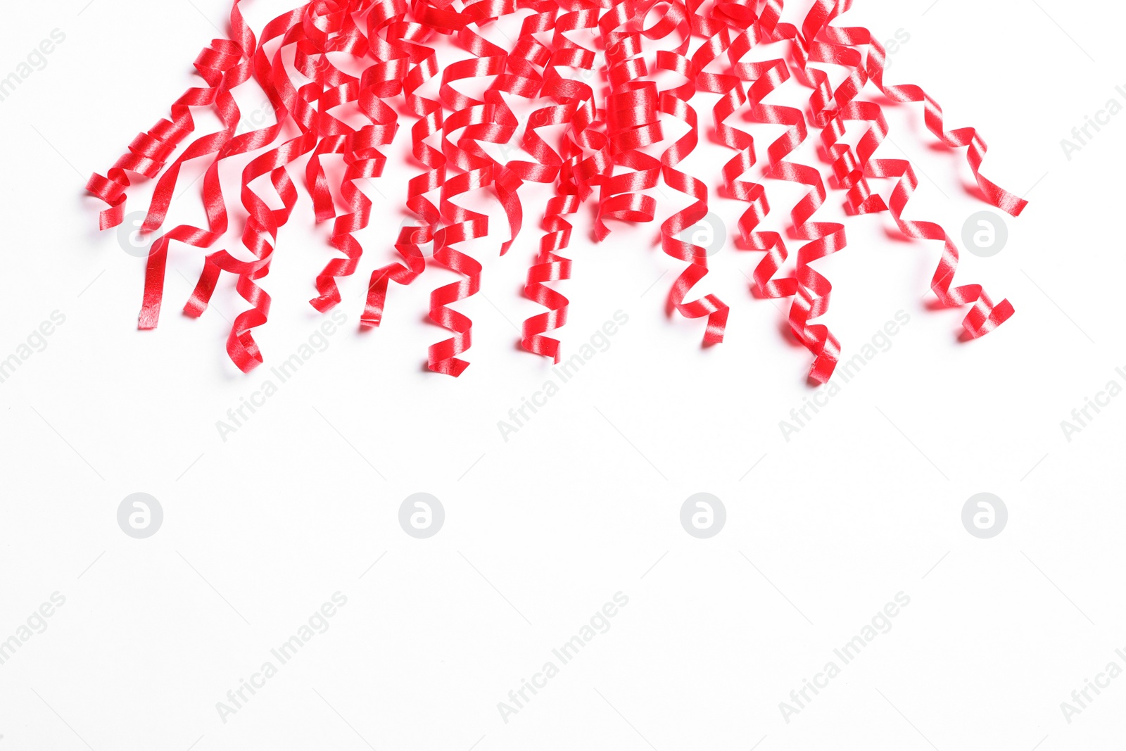 Photo of Red serpentine streamers on white background, above view