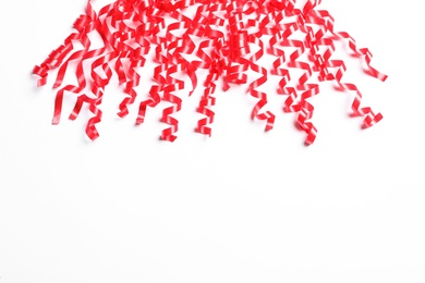 Photo of Red serpentine streamers on white background, above view