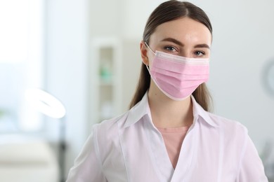 Photo of Cosmetologist in medical uniform in clinic, space for text