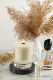 Photo of Composition with burning soy candle on white marble table