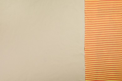 Photo of Striped beach towel on sand, top view. Space for text