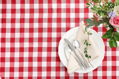 Stylish setting with cutlery, plates, napkin and floral decor on table, top view. Space for text