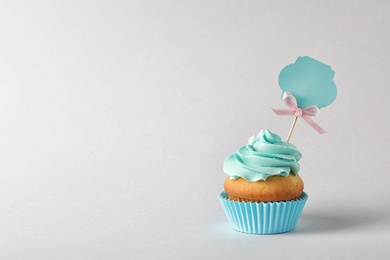 Photo of Delicious birthday cupcake and space for text on gray background