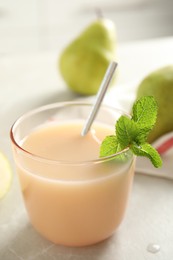 Tasty pear juice with mint on light grey table, closeup