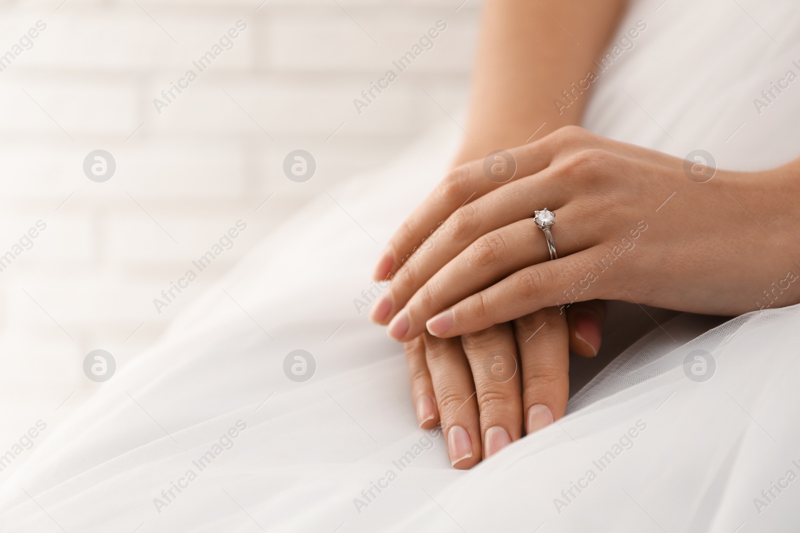 Photo of Young bride wearing beautiful engagement ring, closeup