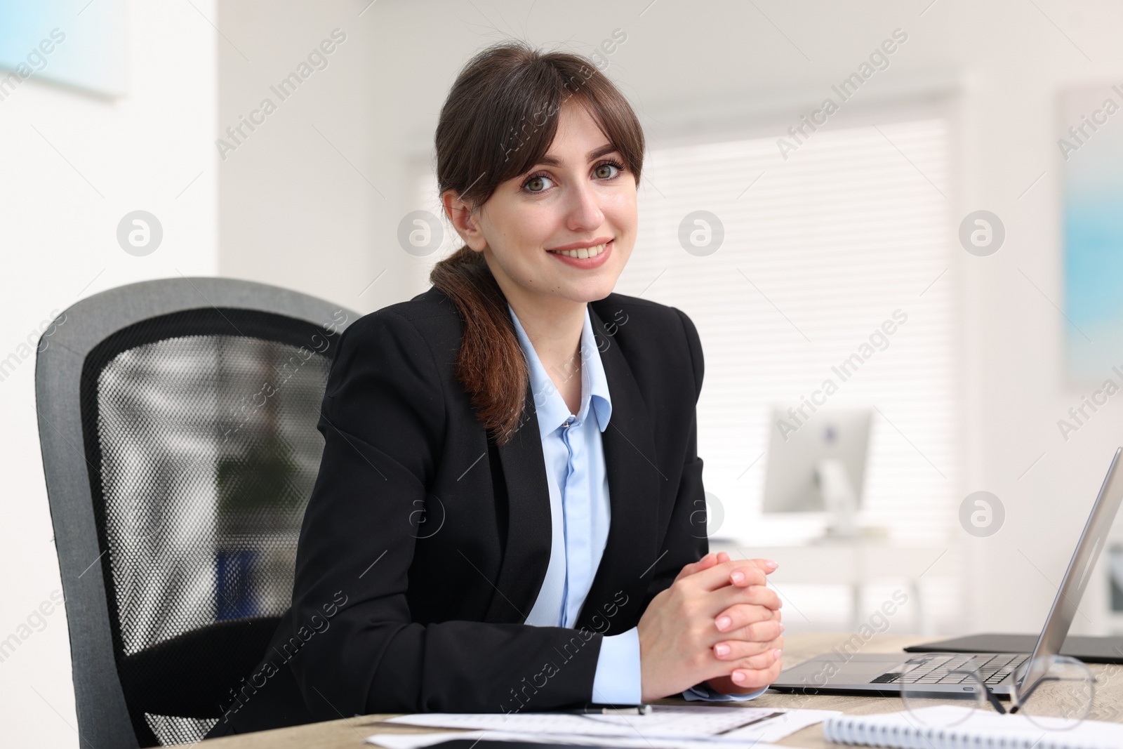 Photo of Portrait of smiling secretary at table in office