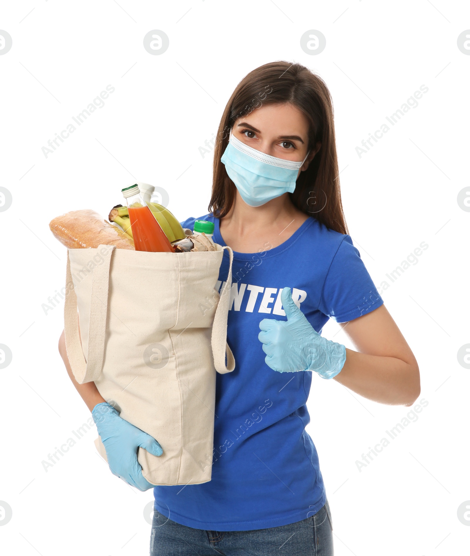 Photo of Female volunteer in protective mask and gloves with products on white background. Aid during coronavirus quarantine