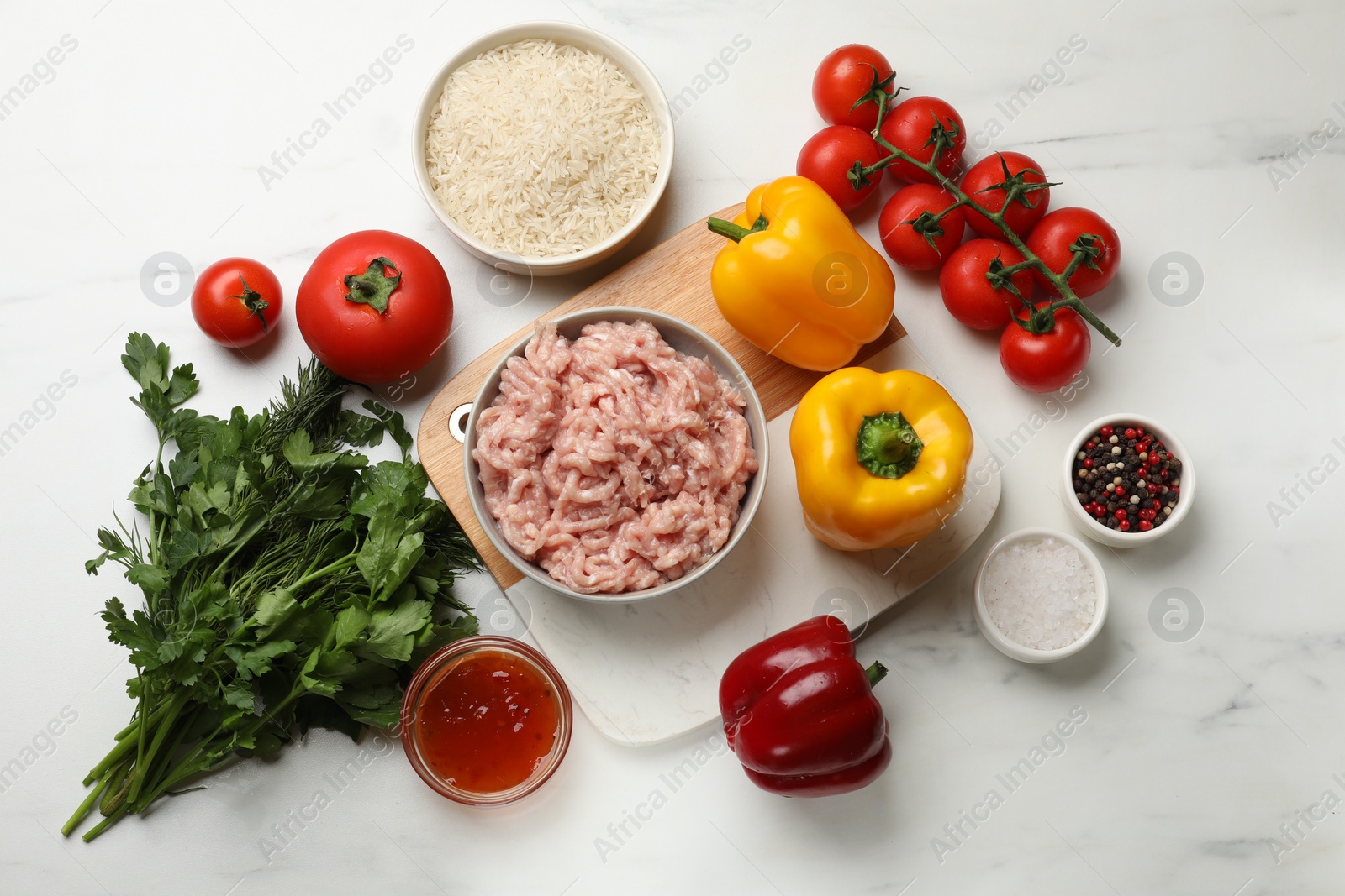 Photo of Making stuffed peppers. Ground meat and other ingredients on white marble table, flat lay