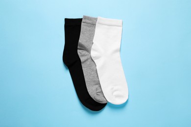 Photo of Different socks on light blue background, flat lay