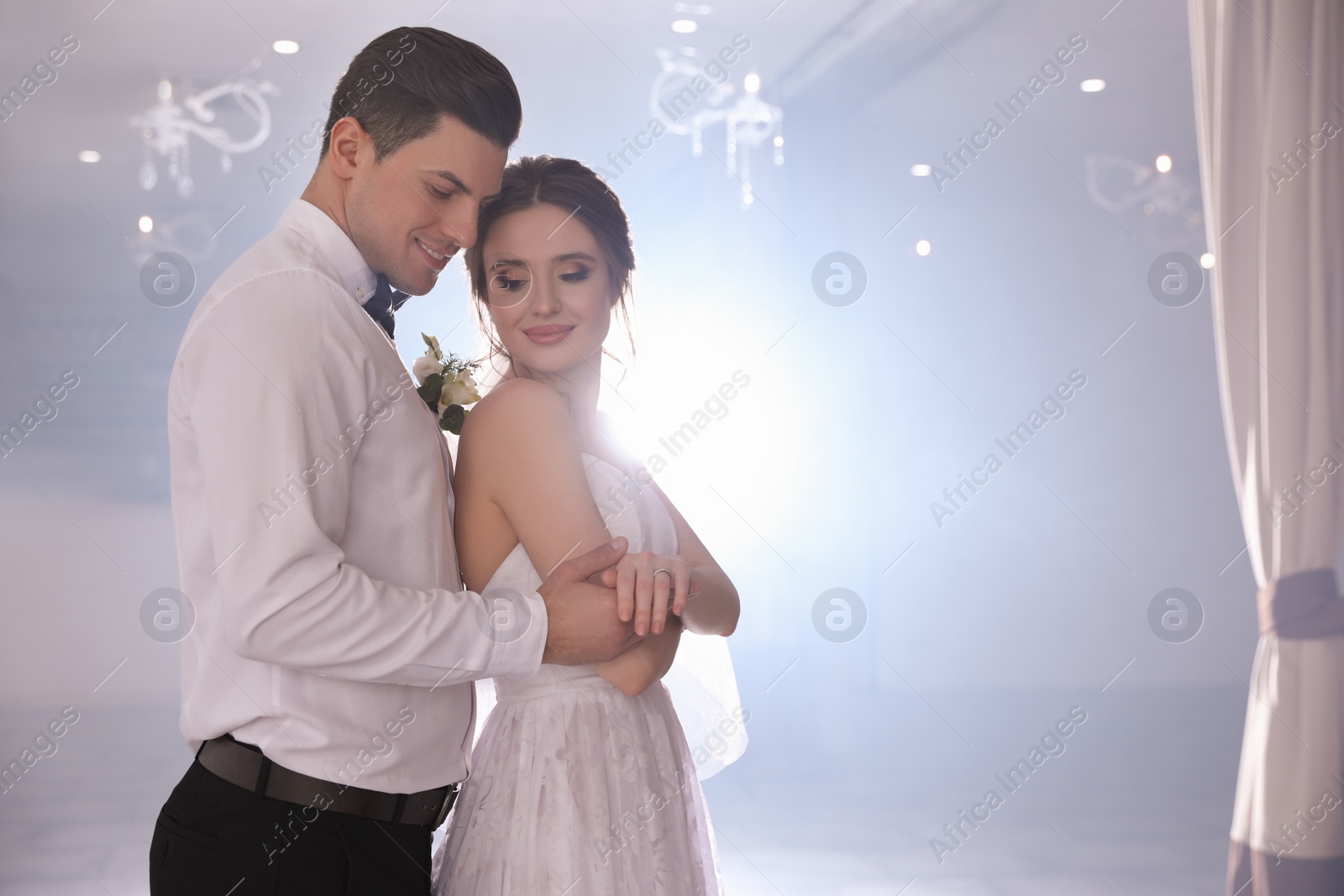 Photo of Happy newlywed couple dancing together in festive hall