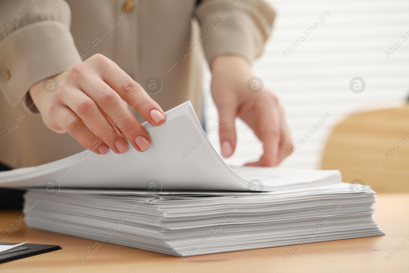 Photo of Woman working with documents at table in office, closeup