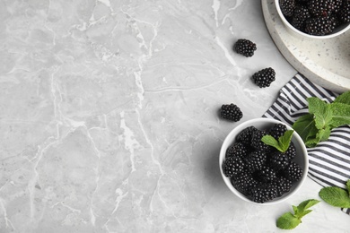 Photo of Flat lay composition of tasty blackberries and space for text on grey marble table