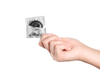 Woman holding condom in wrapper on white background, closeup