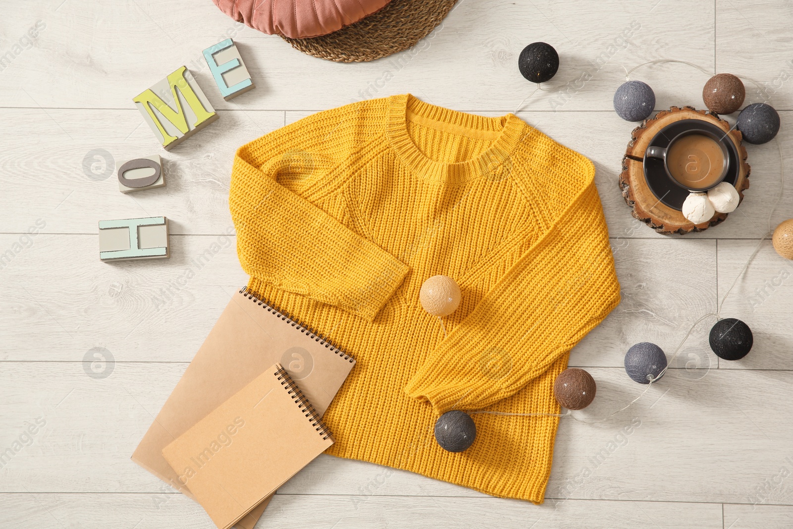 Photo of Flat lay composition with cozy knitted sweater on wooden floor