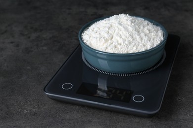 Electronic scales with flour on black table