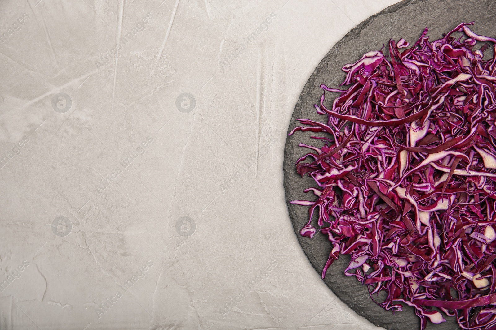 Photo of Plate with chopped red cabbage on light background, top view