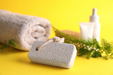 Photo of Pumice stone and towel on yellow background