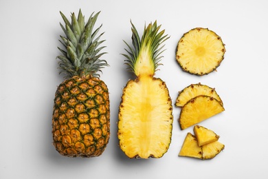 Composition with raw cut pineapples on white background, top view