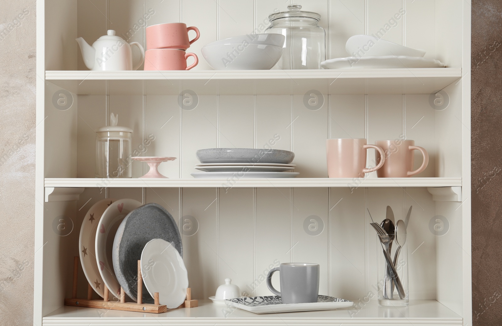 Photo of Stylish storage stand with different ceramic dishware at home