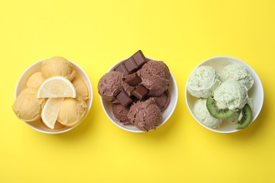 Photo of Different delicious ice creams on yellow background, flat lay