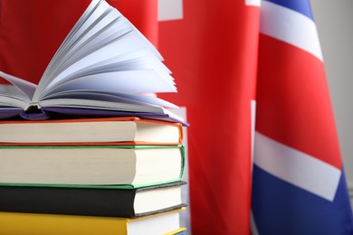 Photo of Learning foreign language. Different books against flag of United Kingdom, space for text