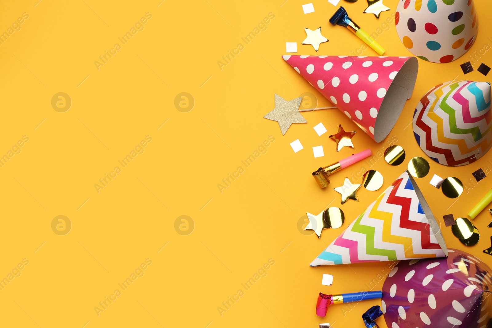 Photo of Flat lay composition with party hats and other festive items on orange background. Space for text