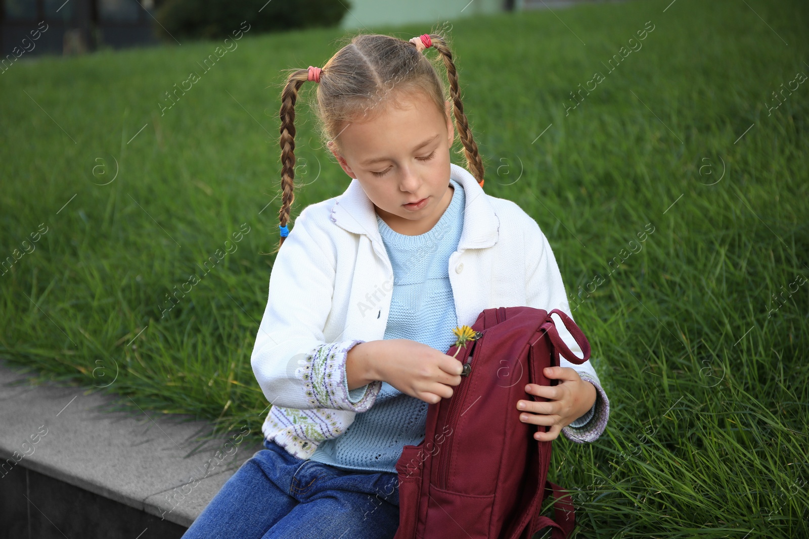 Photo of Cute little girl with backpack on city street