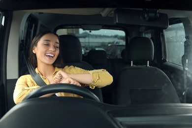Photo of Listening to radio. Beautiful woman enjoying music in car, view through windshield
