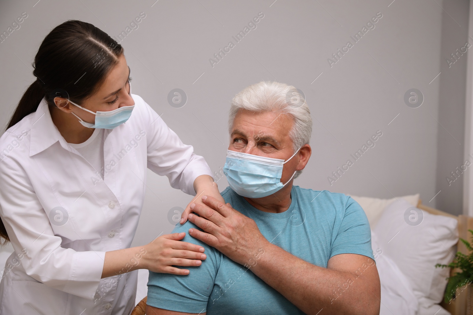 Photo of Doctor taking care of senior man with protective mask at nursing home