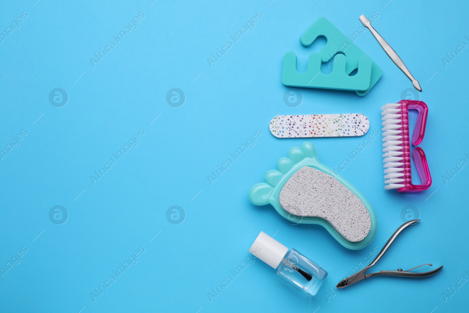 Photo of Set of pedicure tools on light blue background, flat lay. Space for text