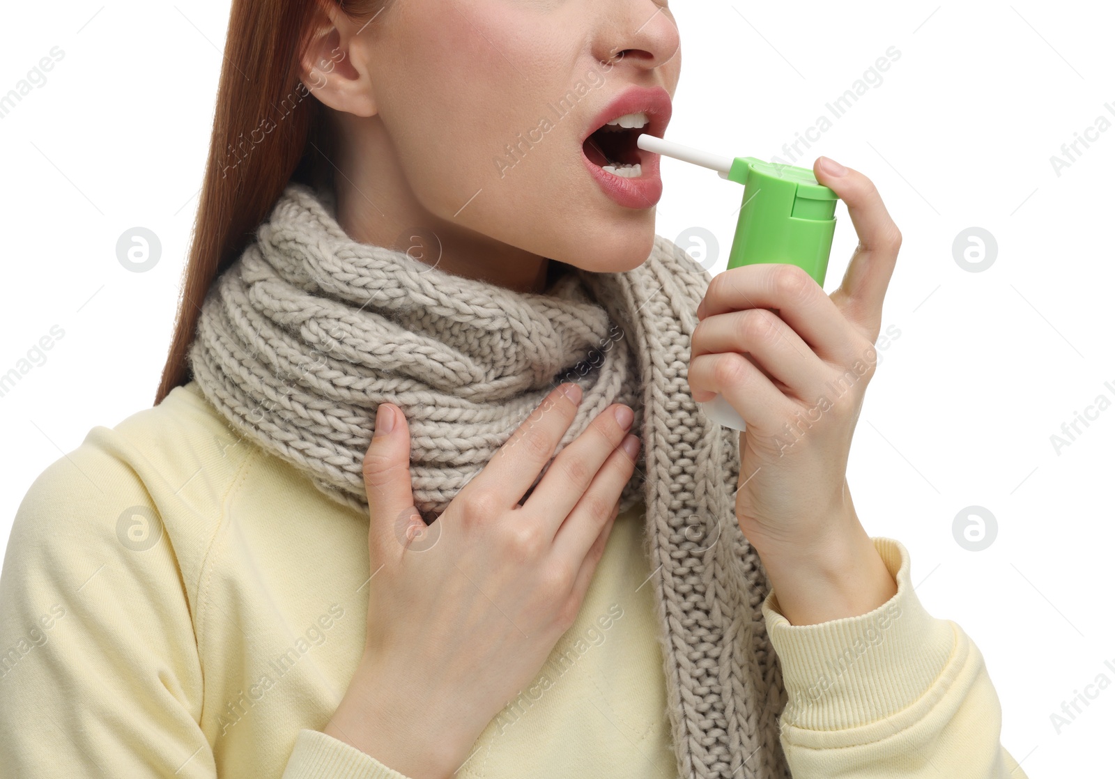 Photo of Young woman with scarf using throat spray on white background, closeup