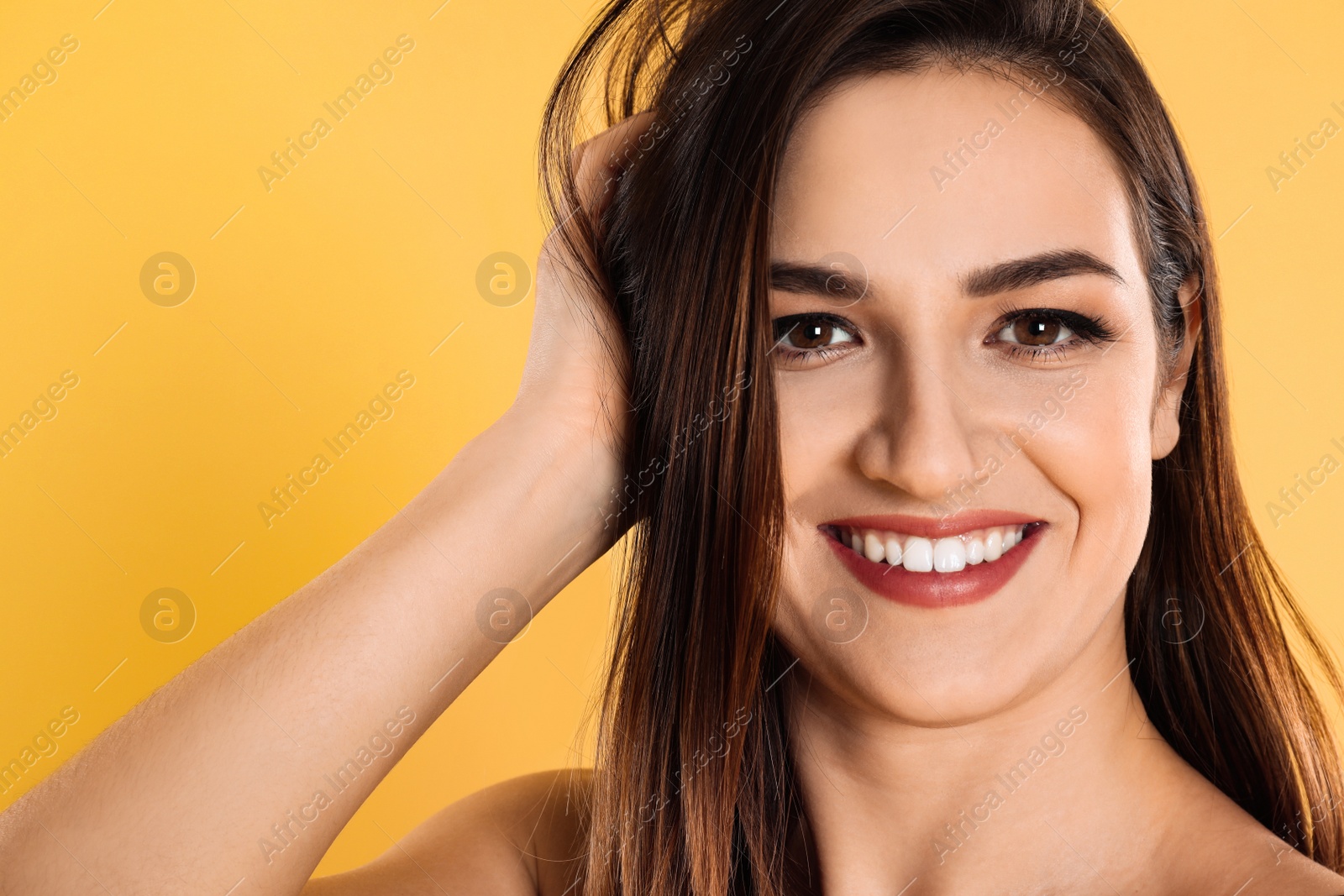 Photo of Happy beautiful young woman on yellow background