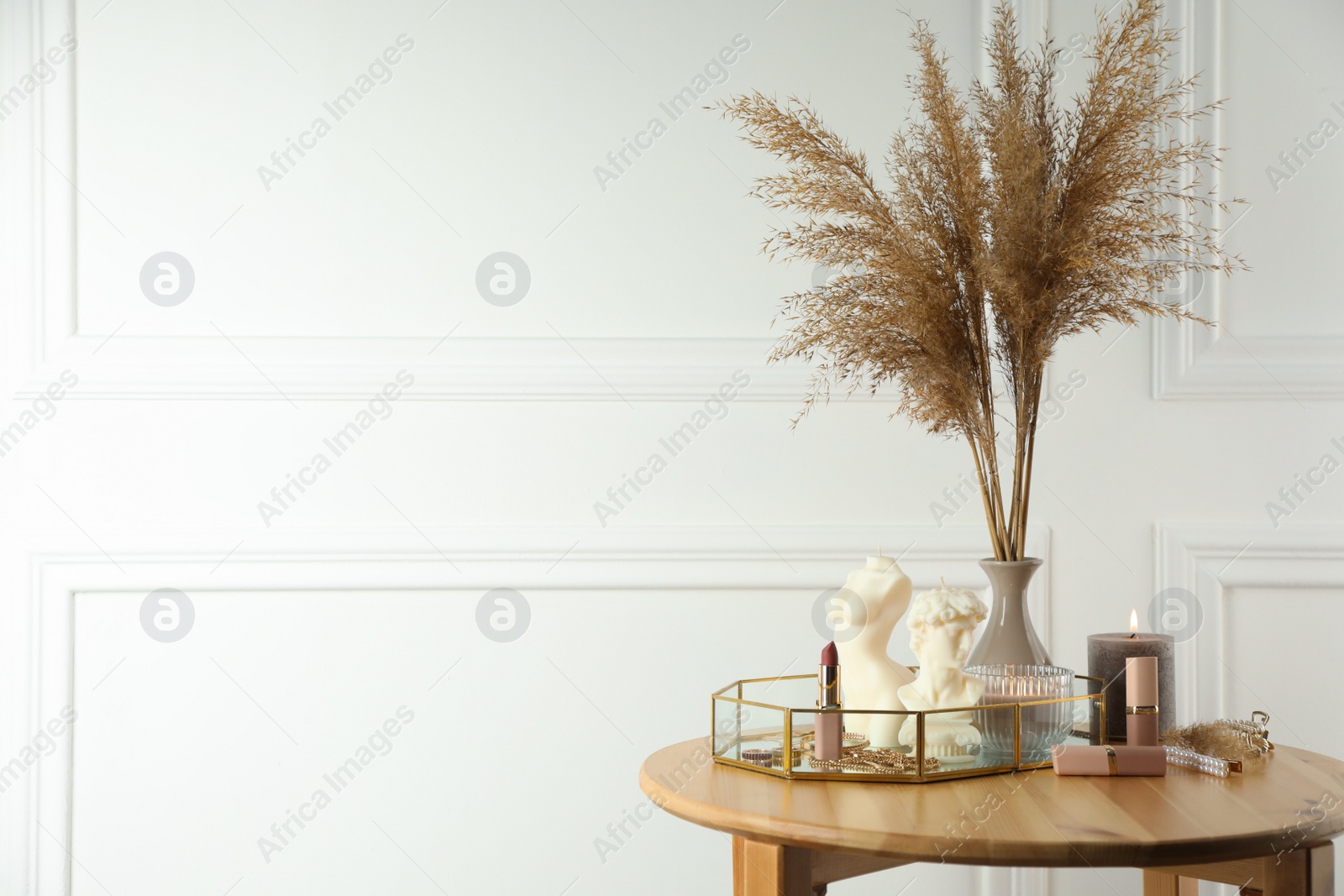 Photo of David bust and female body shaped candles on wooden table, space for text. Stylish decor