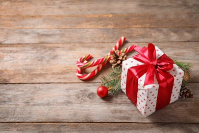 Photo of Beautiful composition with gift box and Christmas decorations on wooden table